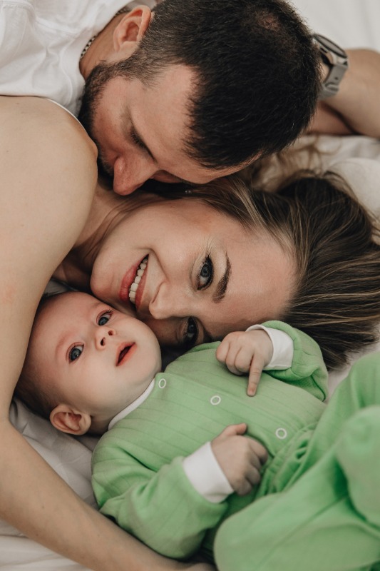 Счастливые родители обнимают младенца